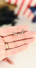 Silver stainless steel star climber earrings held in hand, minimalist celestial studs by Caramel Sky Co.